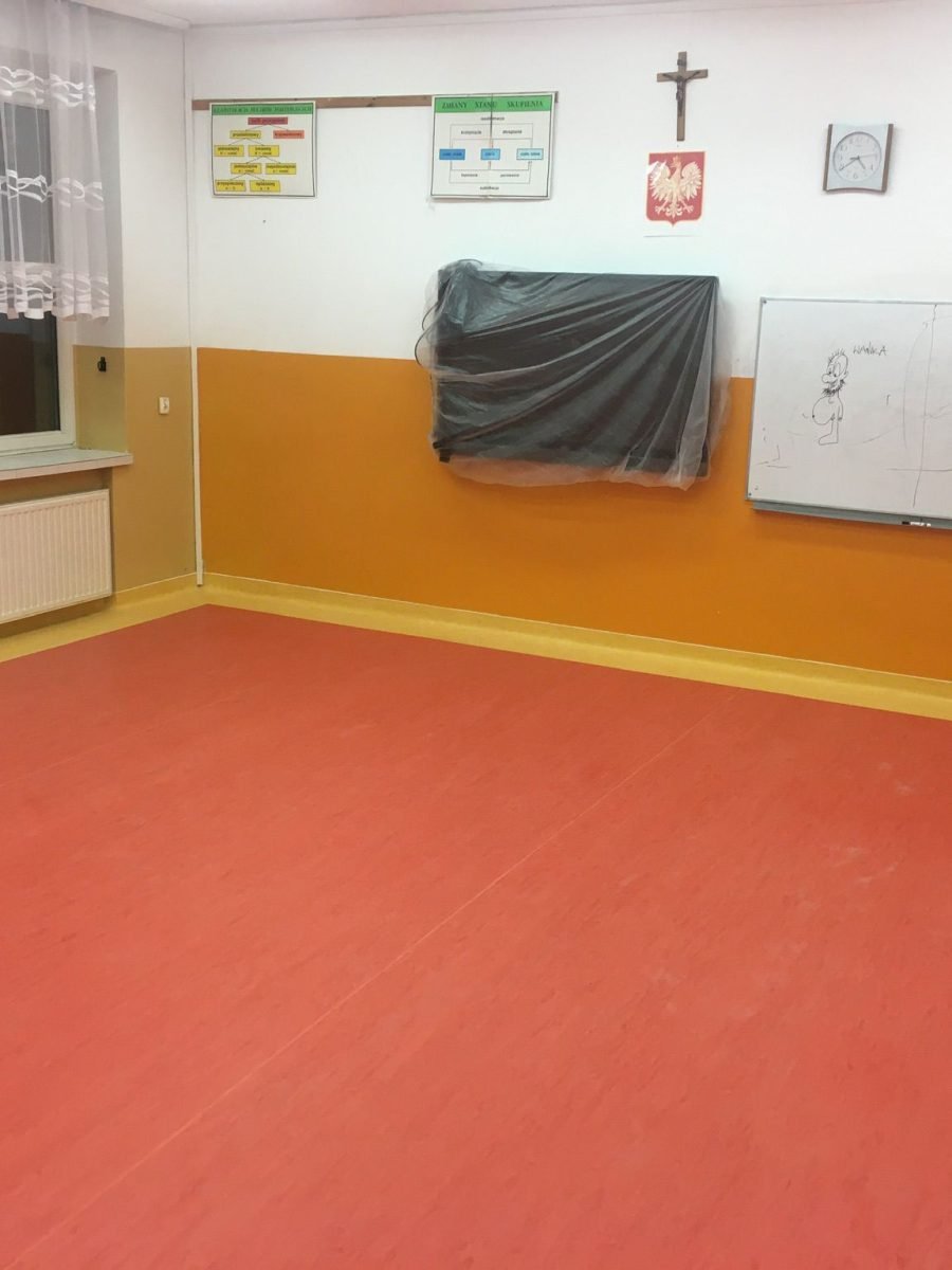 Montaż wykładziny PCV w intensywnym czerwonym kolorze w klasie szkoły w Suwałkach